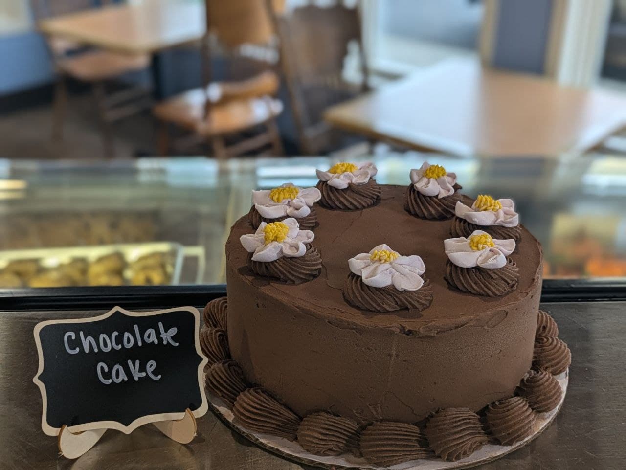 Chocolate cake with white piped flowers on the counter